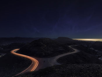 Scenic view of mountain road against sky at night