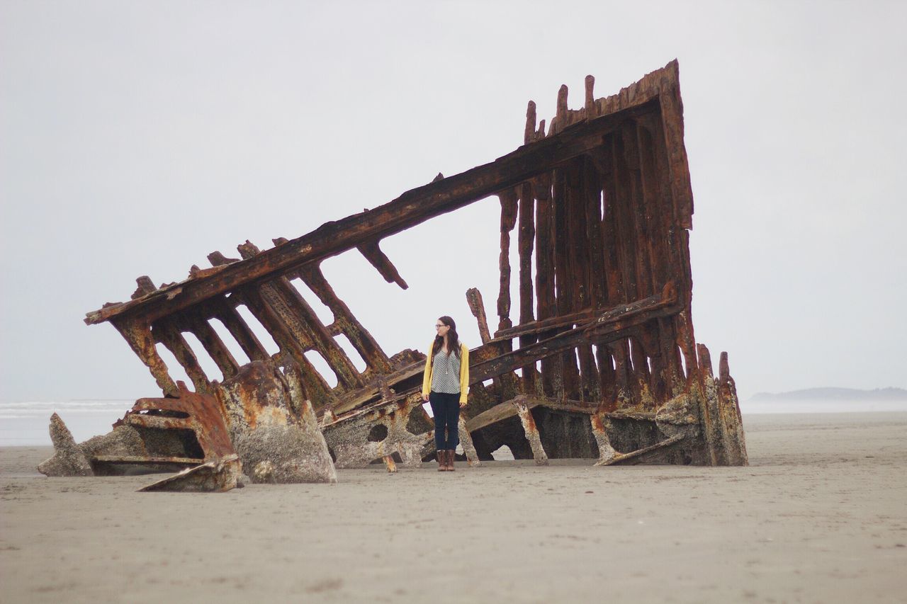 built structure, beach, clear sky, architecture, abandoned, sky, sea, damaged, sand, obsolete, old, deterioration, run-down, building exterior, wood - material, horizon over water, animal themes, shore, water, day