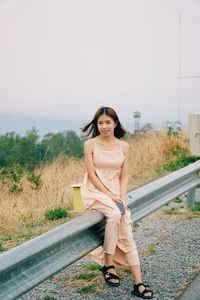 Portrait of beautiful woman standing against sky