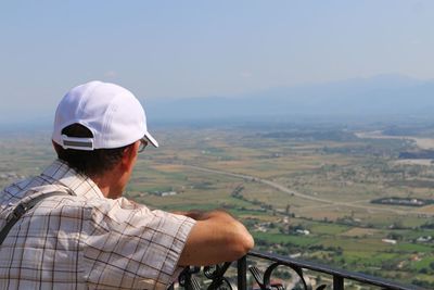 Rear view of man looking at landscape against sky