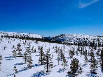 Scenic view of snowcapped mountains against blue sky