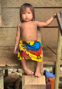 Cute girl looking away while standing on wood