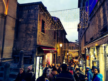 People walking on street amidst buildings in city