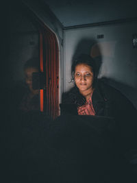 Portrait of young woman standing against wall