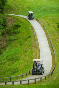 People riding golf carts on footpath