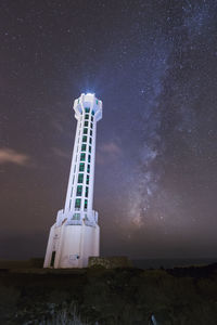 Low angle view of lighthouse against sky at night