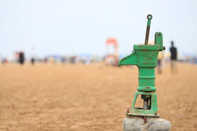 Metal equipment at beach against sky