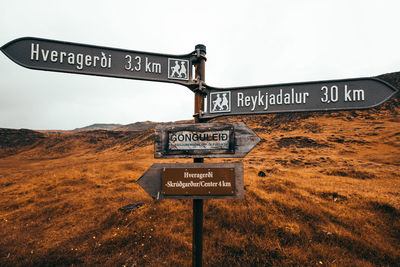 Information sign on road against sky