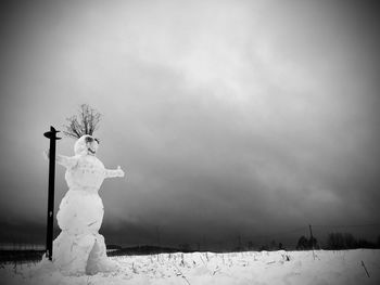 Snow covered statue against sky
