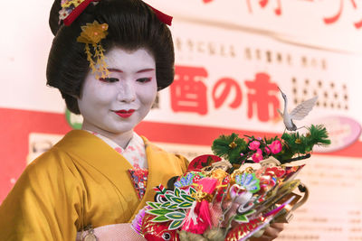 Portrait of young woman holding flowers