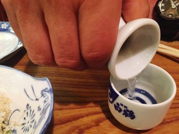 Cropped image of woman holding coffee cup