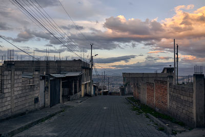 Street amidst buildings against sky during sunset