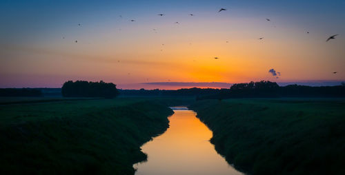 High angle view of stream amidst landscape at sunset