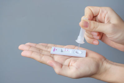 Close-up of person holding hands against white background