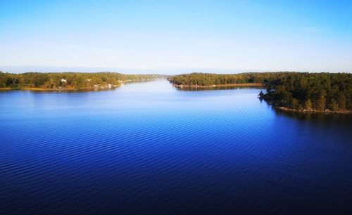 Scenic view of lake against clear blue sky