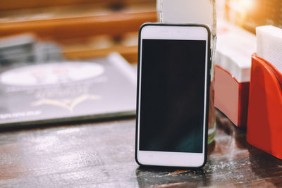 Close-up of mobile phone on wooden table