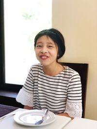 Portrait of smiling woman sitting at table