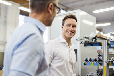 Portrait of smiling businessman with colleague in factory