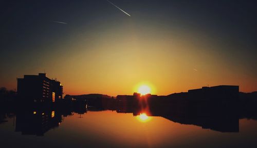 Reflection of buildings in water at sunset