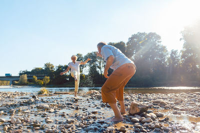Senior couple playing at riverbank