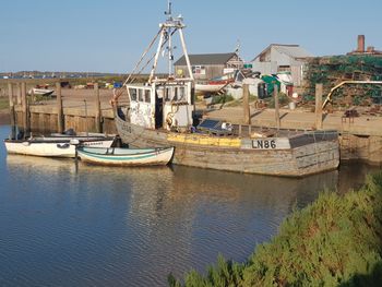 Boats moored at port against sky