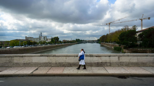 Rear view of woman on bridge against sky