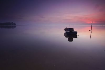 Reflection of silhouette water in lake against sky during sunset