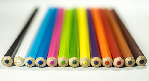 Close-up of colored pencils over white background