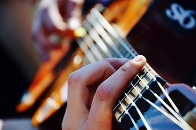 Cropped hands playing guitar