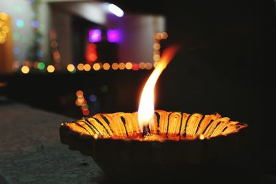 Close-up of lit diya at night during diwali