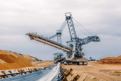 Cranes at construction site against sky