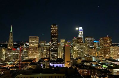 Illuminated cityscape against sky at night