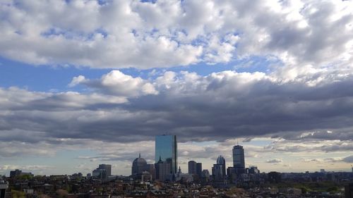 Buildings in city against cloudy sky