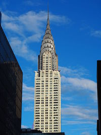 Low angle view of modern buildings against blue sky