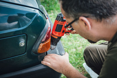Close-up portrait of man holding car