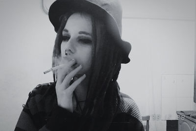 Portrait of young woman smoking cigarette