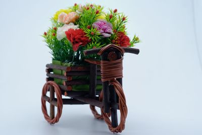 Artificial flower decoration on toy motorcycle against white background
