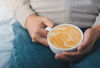 Midsection of woman holding coffee cup