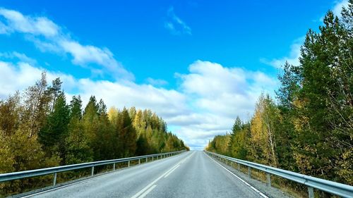 Road amidst trees against sky
