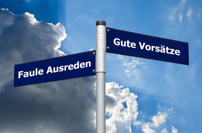 Low angle view of road sign against sky