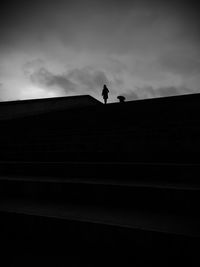 Low angle view of silhouette woman standing on staircase