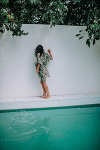 Rear view of woman standing in swimming pool