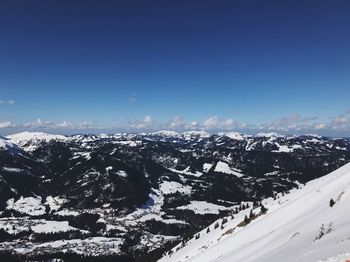 Scenic view of snowcapped mountains against blue sky