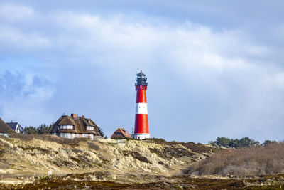 Lighthouse by sea against sky