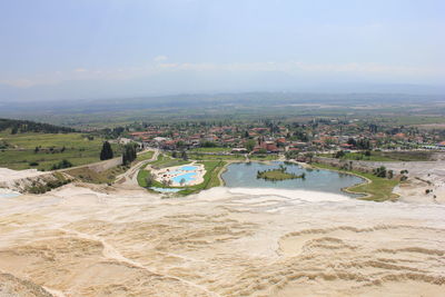 Scenic view of field and village against sky