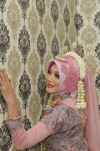 Portrait of smiling young woman with pink petals