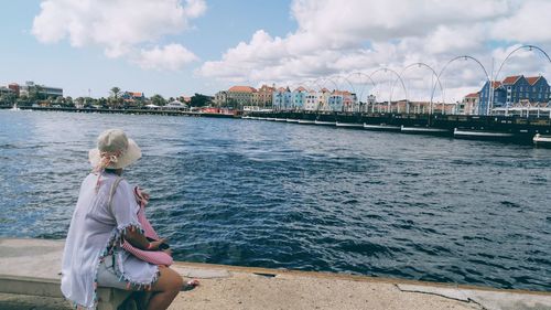 Woman looking at sea against sky