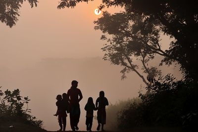 Silhouette people against sky during sunset