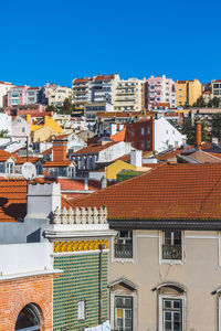 Houses in town against clear blue sky