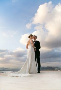 Low angle view of bride and groom standing on floor against sky at santorini